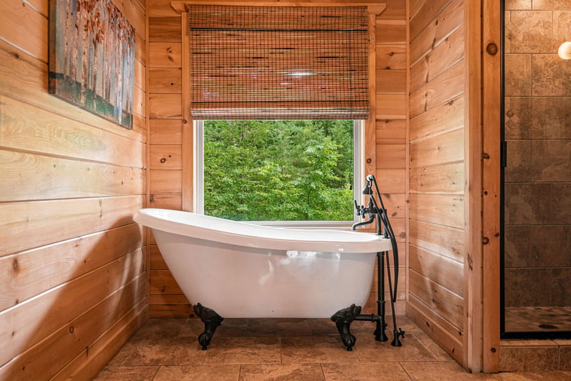 Slip into this vintagestyle clawfoot tub and let your worries melt away as you gaze out at lush forest views through the window—pure rustic luxury for your private retreat.