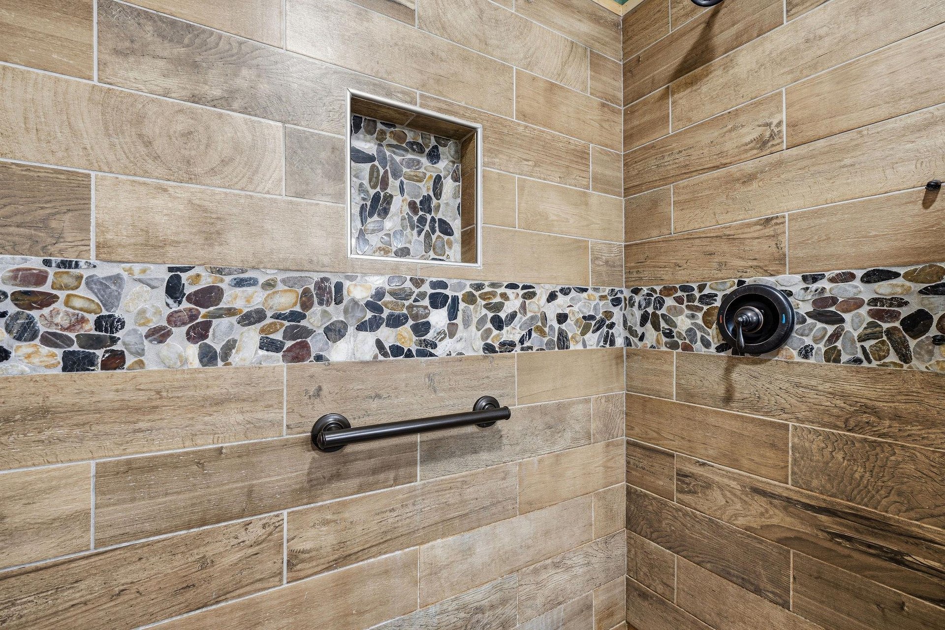 Refresh and rejuvenate in your beautifully tiled walkin shower, featuring natural stone accents and modern fixtures designed for your comfort.
