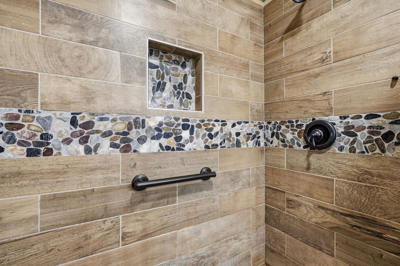 Refresh and rejuvenate in your beautifully tiled walkin shower, featuring natural stone accents and modern fixtures designed for your comfort.