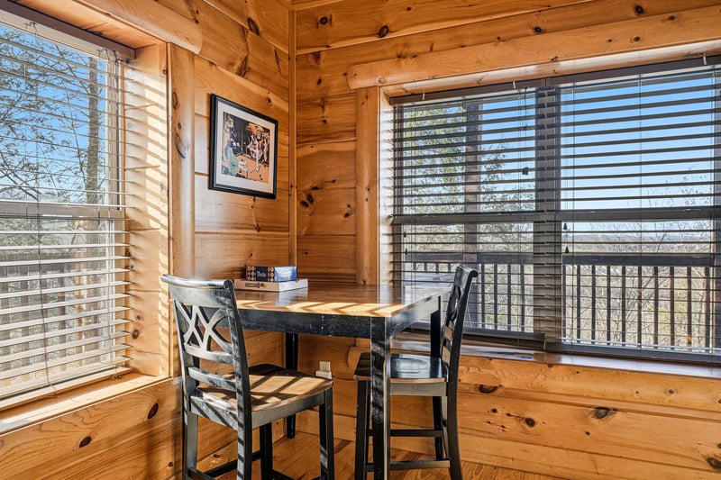 Your cozy dining nook features warm wood walls and large windows that flood the space with natural light for memorable meals.