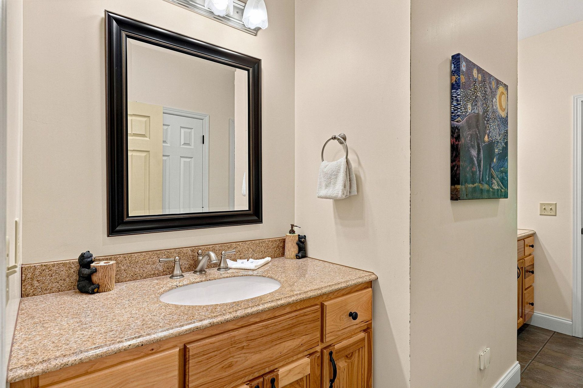 Step into your bright, welcoming bathroom with warm wood vanity, granite counters, and calming neutral tones. Fresh towels and thoughtful décor await your arrival.