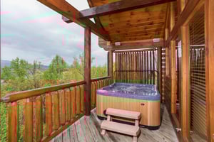 Hot tub on a covered deck at Howlin in the Smokies, a 2 bedroom cabin rental located in Pigeon Forge