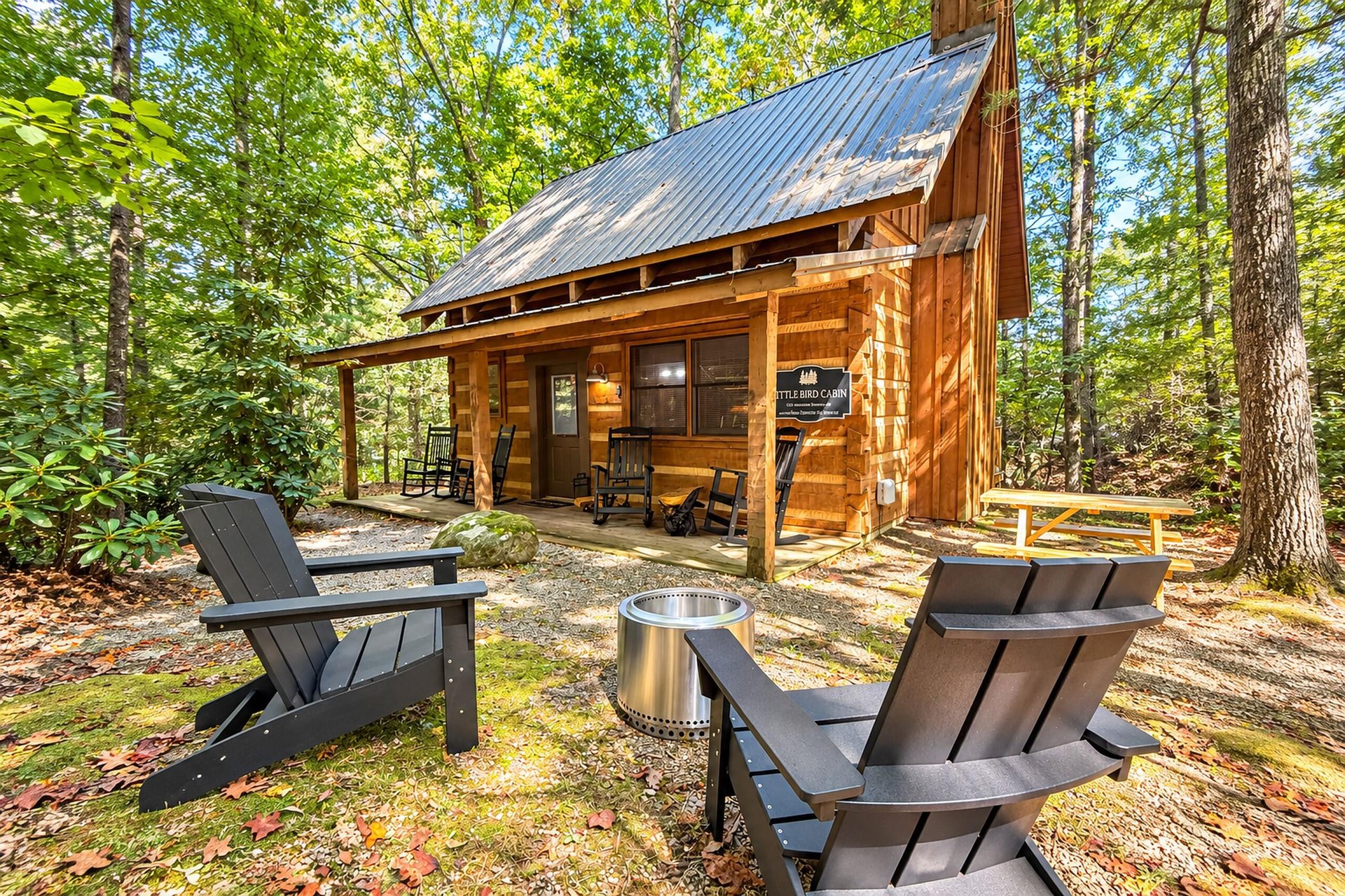 A charming Aframe cabin nestled in a lush forest offers a private escape. Gather around the fire pit in cozy Adirondack chairs and let the peaceful woodland setting restore your spirit.