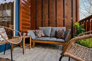 Relax in your private outdoor haven with comfortable rattan seating and lush plants.