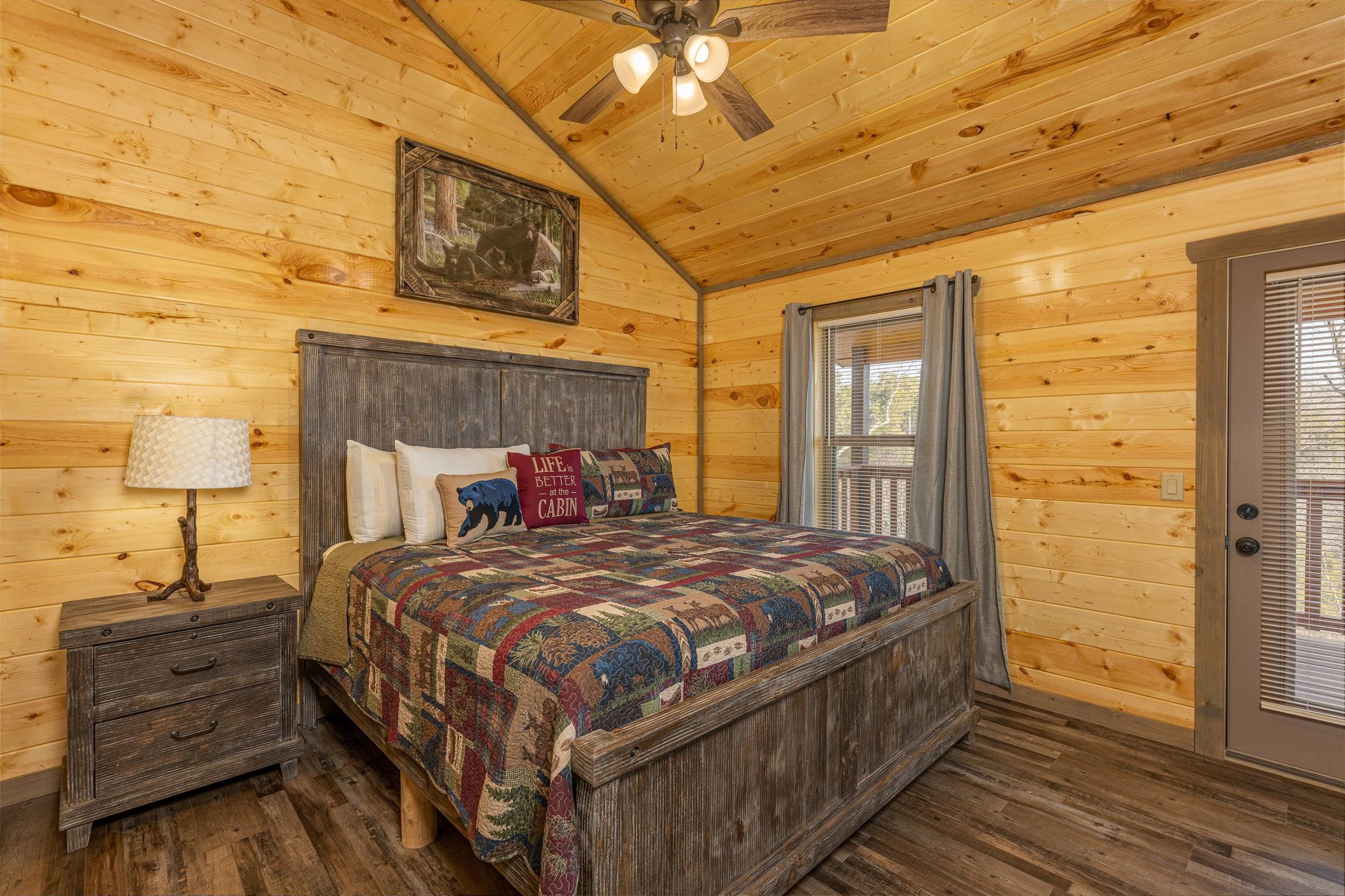 Bedroom with a night stand, lamp, and deck access at Everlys Splash, a 4 bedroom cabin rental located in Pigeon Forge