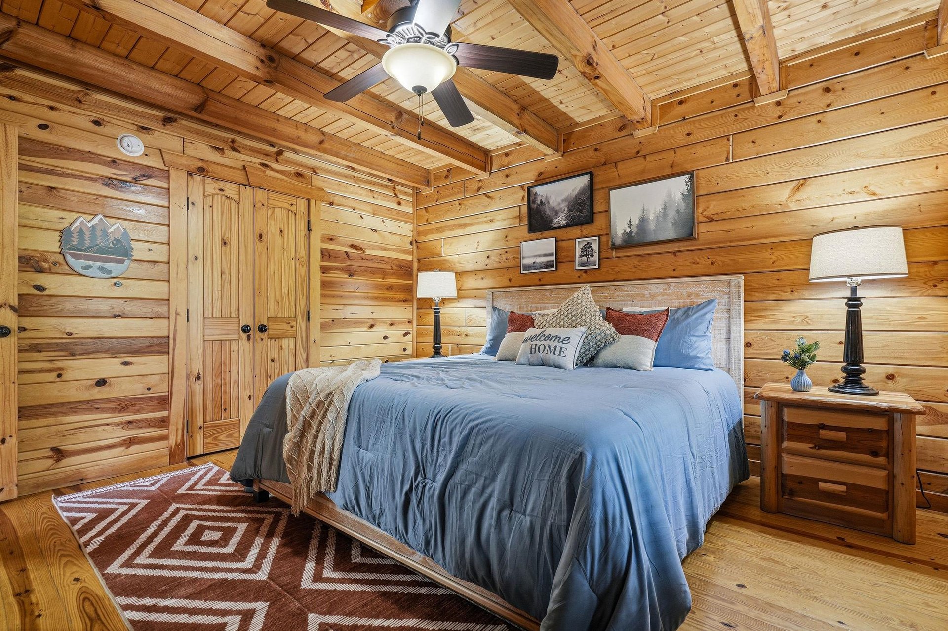 Your cozy log cabin bedroom awaits with rustic charm, soft linens, and peaceful mountain artwork to lull you into restful sleep.