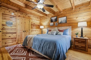 Your cozy log cabin bedroom awaits with rustic charm, soft linens, and peaceful mountain artwork to lull you into restful sleep.