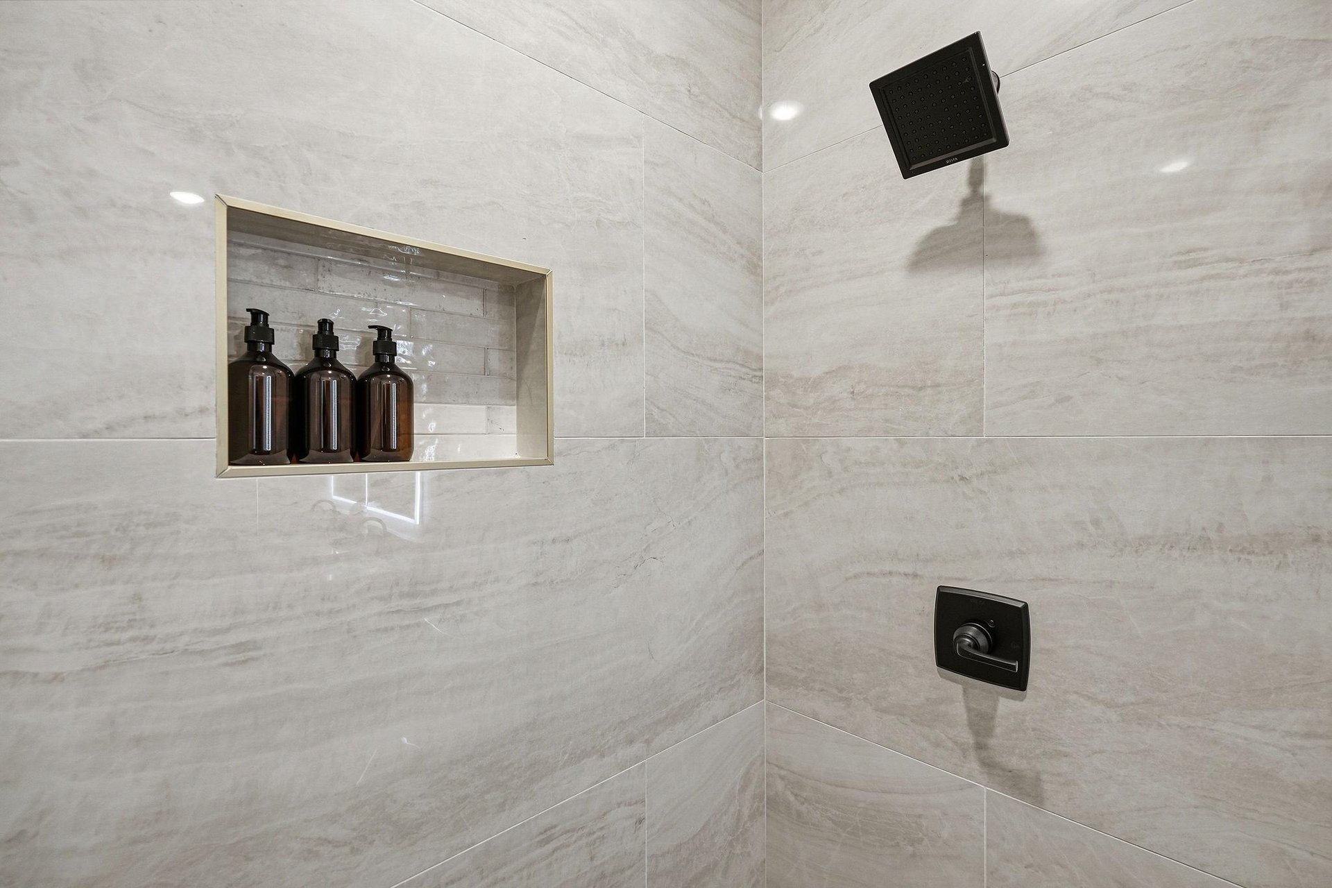 Step into your spalike marble shower with premium amenities and rainfall showerhead for the ultimate relaxation.