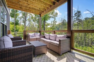 Settle into your private covered terrace and breathe in the fresh forest air. Comfortable seating invites you to unwind surrounded by towering trees and peaceful greenery—your perfect spot to relax wi