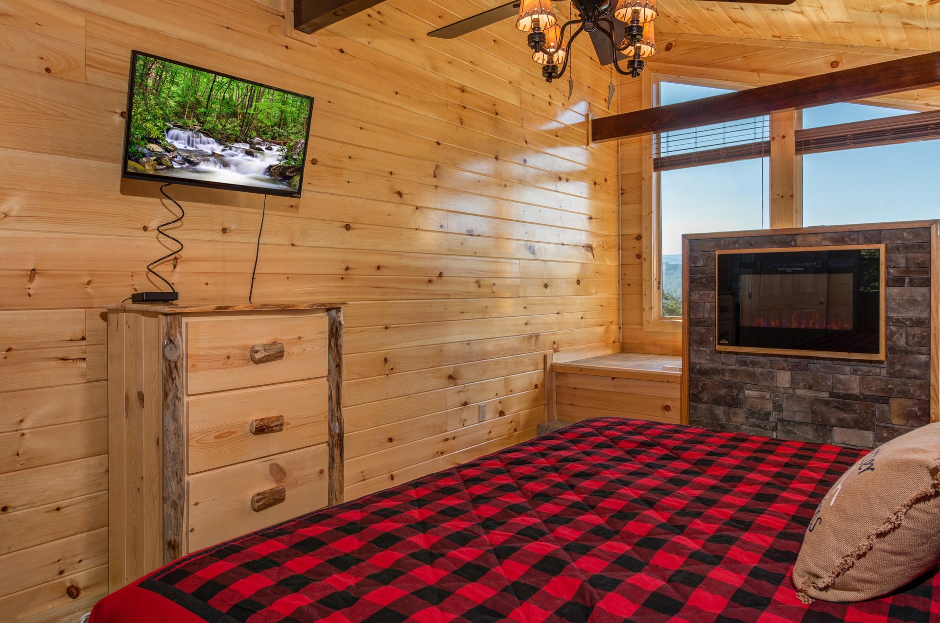 Dresser, TV, and fireplace in a bedroom at Canyon Camp Falls, a 2 bedroom cabin rental located in Pigeon Forge