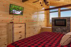 Dresser, TV, and fireplace in a bedroom at Canyon Camp Falls, a 2 bedroom cabin rental located in Pigeon Forge