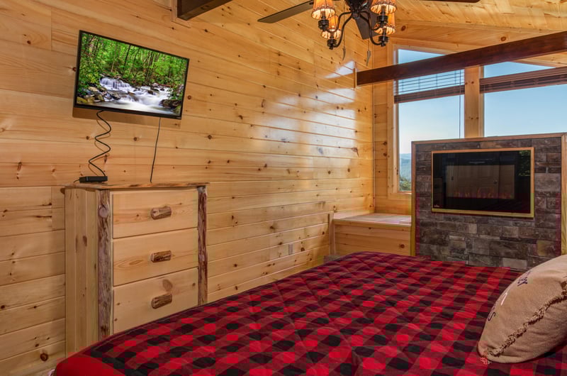 Dresser, TV, and fireplace in a bedroom at Canyon Camp Falls, a 2 bedroom cabin rental located in Pigeon Forge