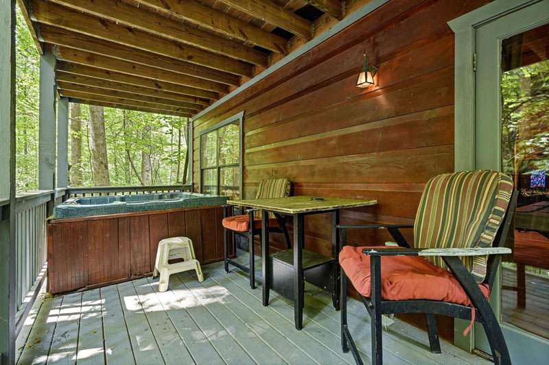 Relax on your private screened porch with a soothing hot tub, cozy seating, and tranquil forest views—your perfect retreat after a day of adventure.