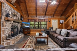 Sink into plush leather sofas by the crackling stone fireplace, where warm wood tones and vaulted ceilings create your cozy mountain retreat.