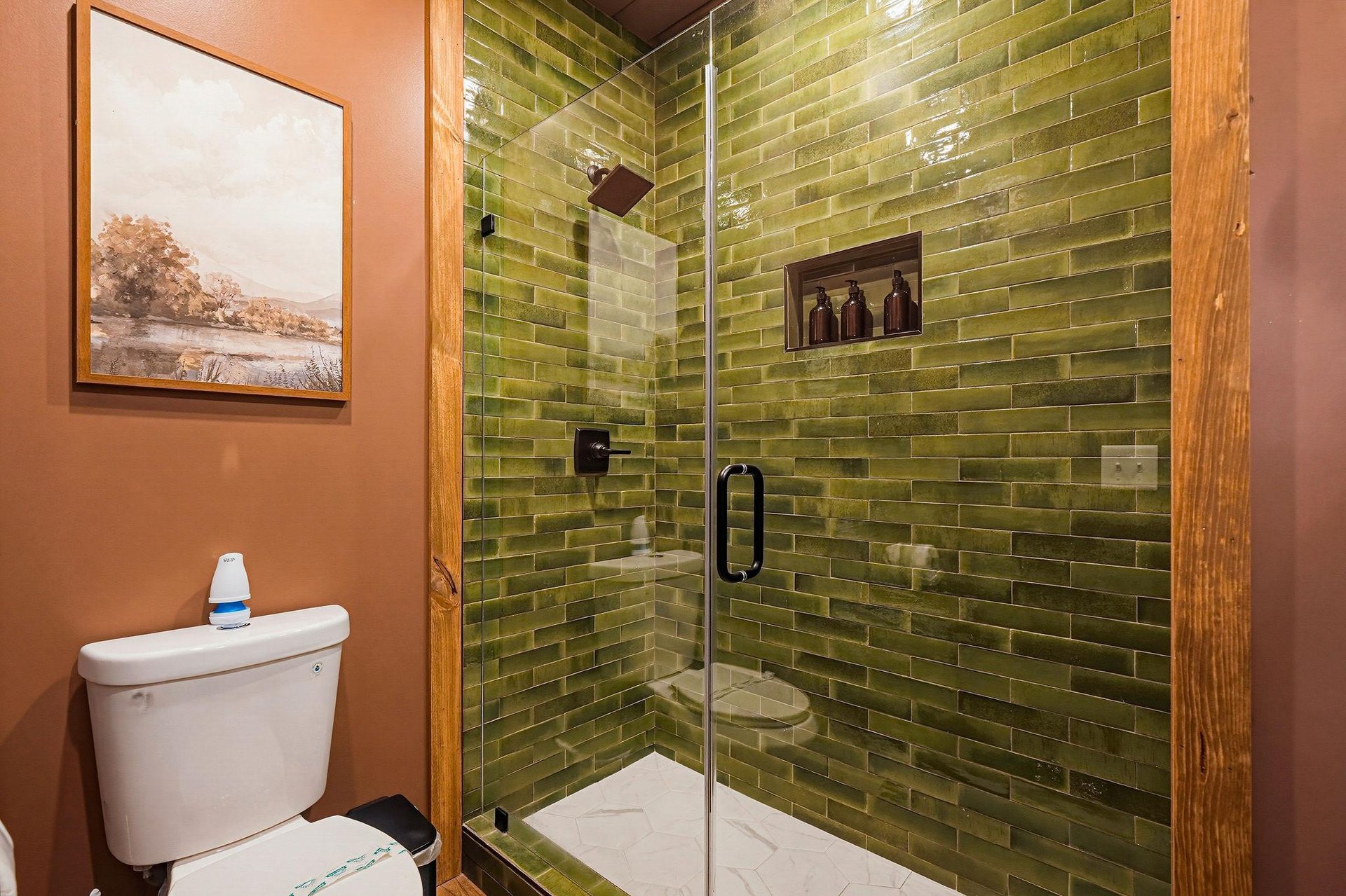 Step into your private spalike shower, where stunning green subway tiles create a peaceful, natureinspired retreat. A builtin niche keeps your essentials close at hand.