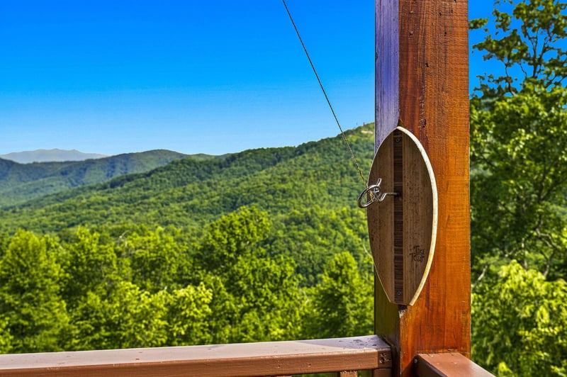 The property sits amid stunning mountain views, framed by lush forested hillsides and clear blue skies—a peaceful natural setting perfect for a getaway.