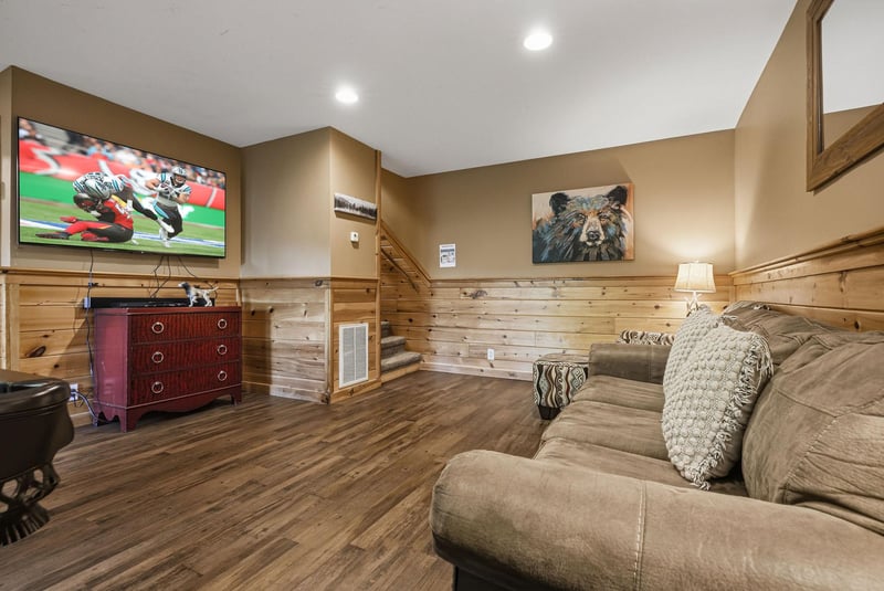 Cozy up in your rustic living space with wood paneling, plush seating, and a large TV for your favorite shows.