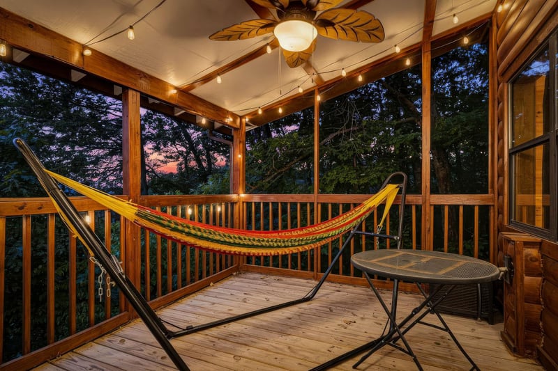 Sway into relaxation in your private screened porch. String lights and a ceiling fan create the perfect twilight ambiance while you gaze out at peaceful wooded surroundings.
