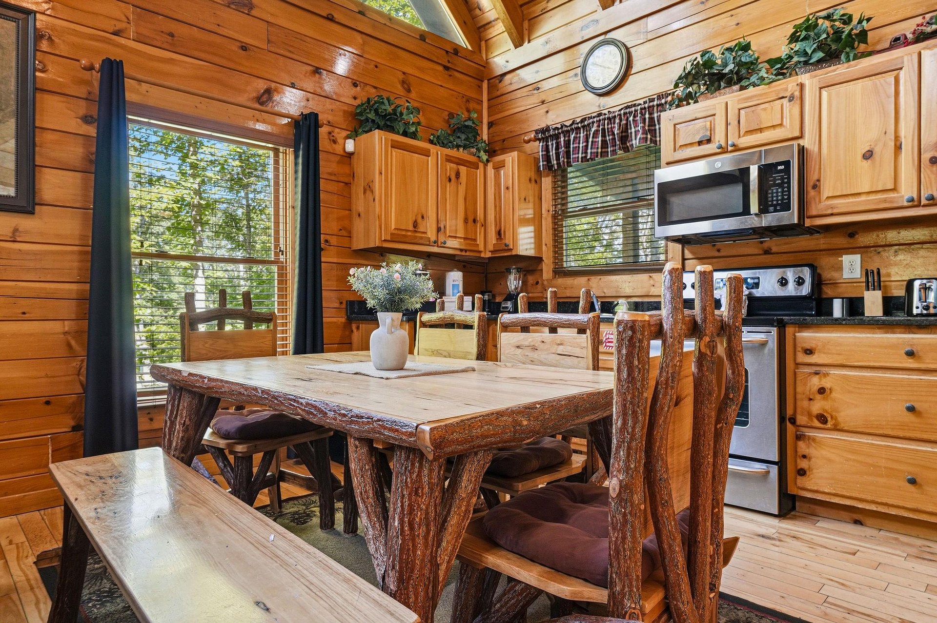 Gather around this handcrafted log dining table where rustic charm meets modern convenience. Your fullyequipped kitchen awaits with all the comforts of home, framed by warm wood and forest views.