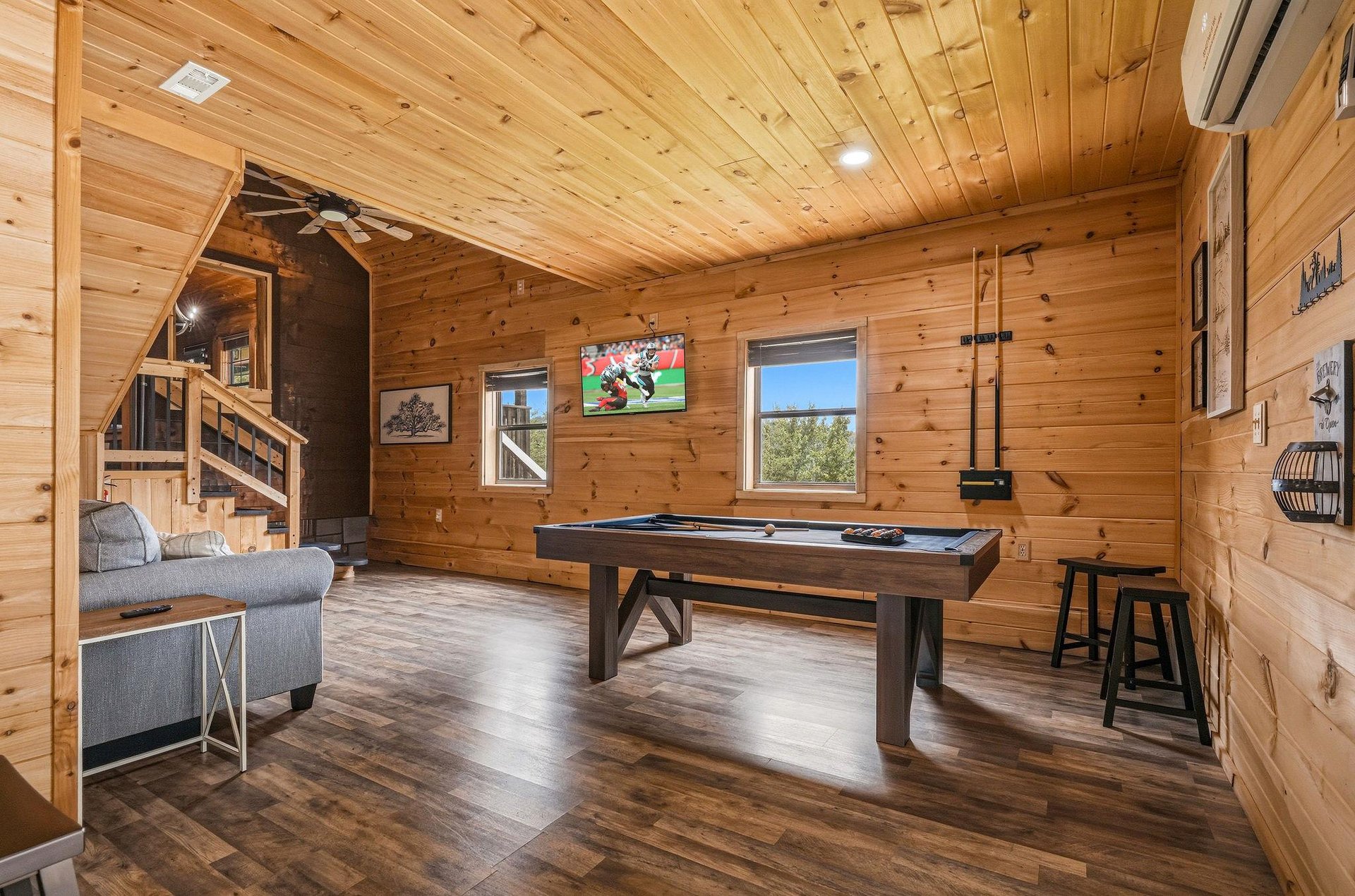 Step into your private game room with rustic wood walls, a billiards table, and cozy seating—perfect for friendly competition and relaxed evenings with loved ones.