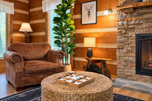 Sink into a plush leather chair by the glowing fireplace, where warm wood walls and rustic stone invite you to unwind completely.