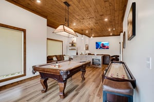 Gather your group in this spacious game room featuring a handsome pool table and shuffleboard. The warm wood ceiling and leather seating create a welcoming space where you can challenge friends to fri