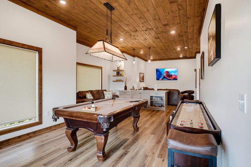 Gather your group in this spacious game room featuring a handsome pool table and shuffleboard. The warm wood ceiling and leather seating create a welcoming space where you can challenge friends to fri
