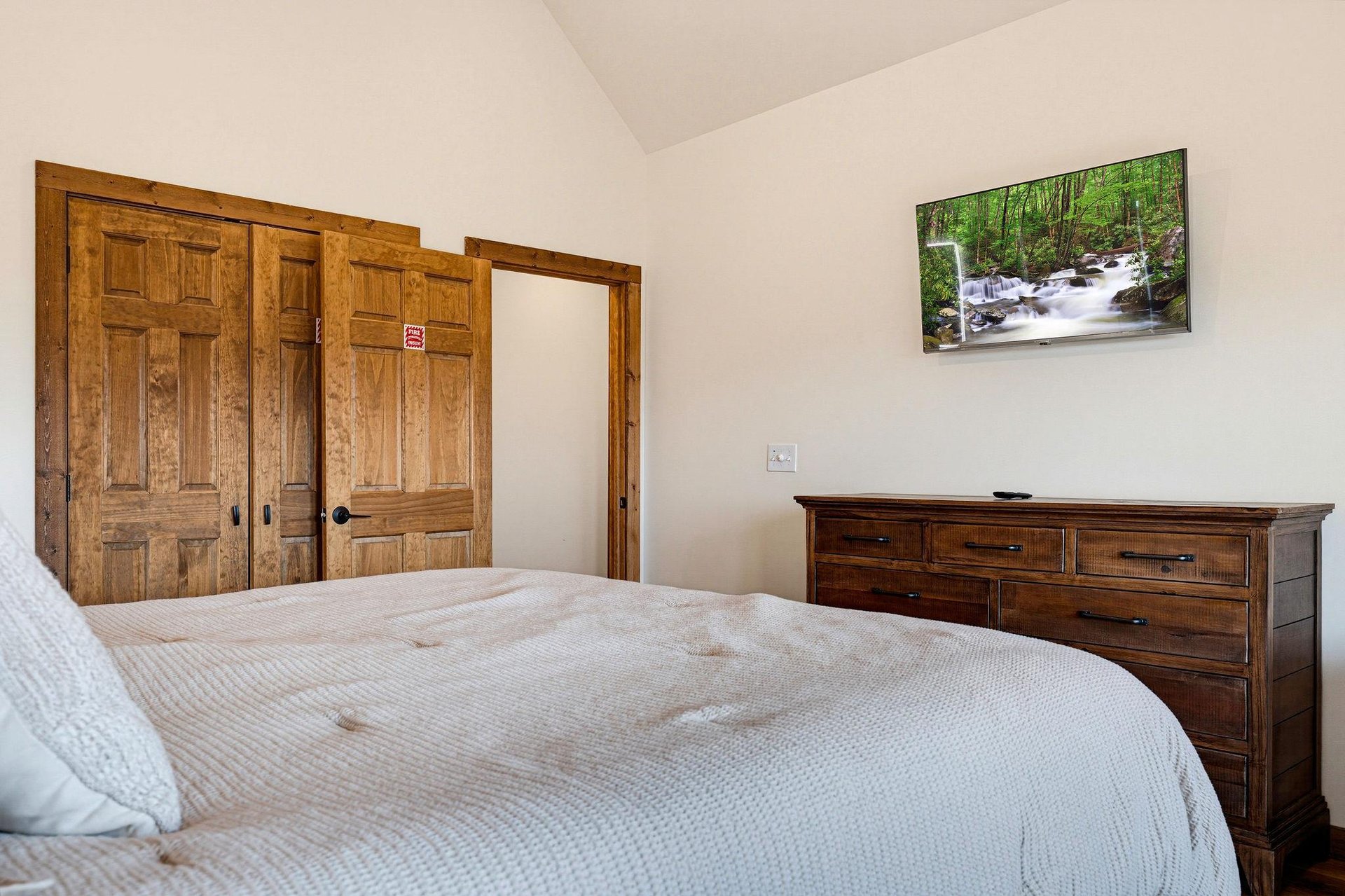 Unwind in this peaceful bedroom with warm wood accents, a comfortable bed, and ample storage for all your belongings.