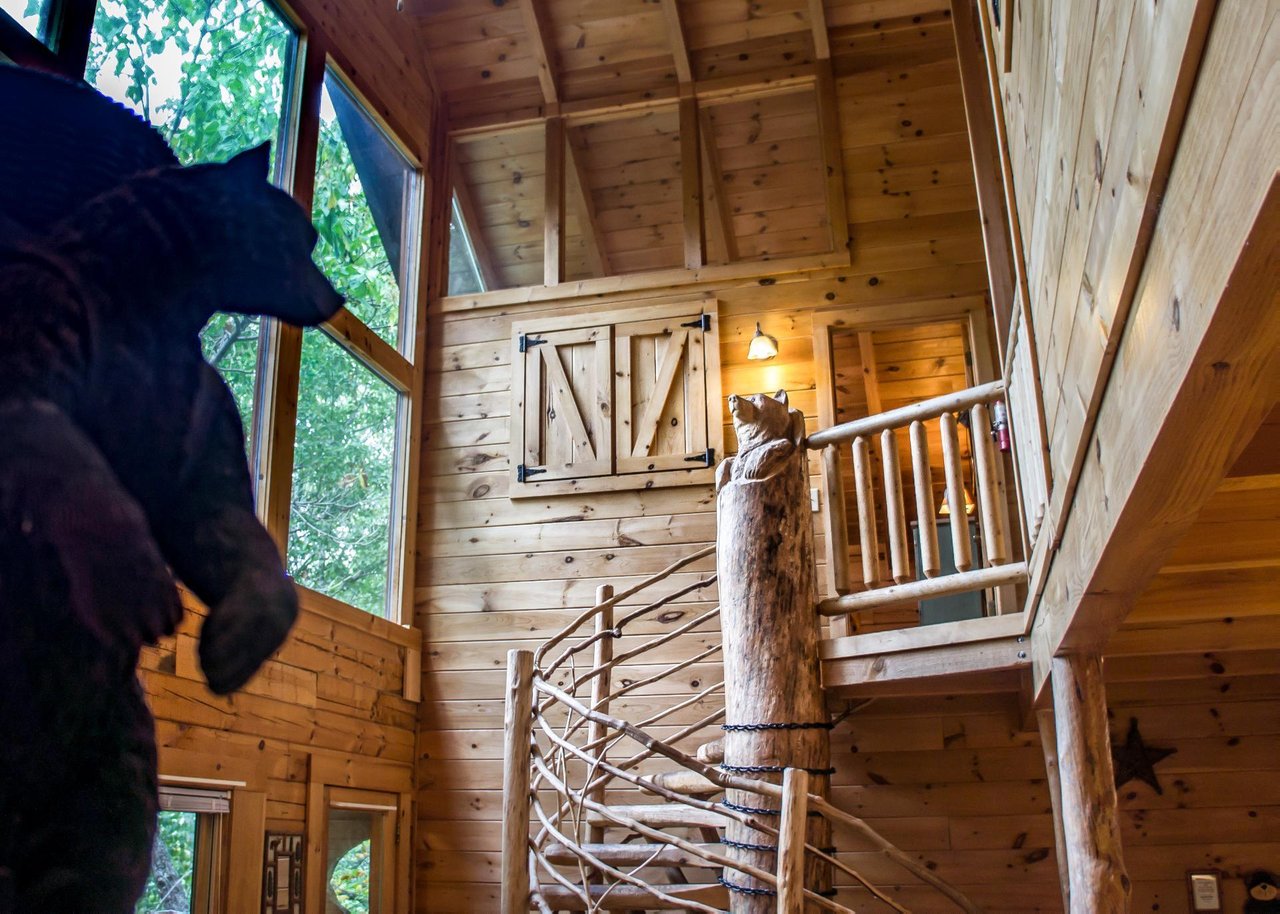 Take the spiral staircase to the second floor and youre greeted by a whimsical bear carving that overlooks the open living area.