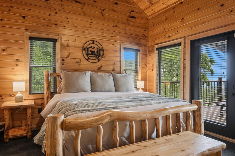 Sink into luxurious comfort in your private bedroom with stunning lake views through French doors and a handcrafted log bed that brings the beauty of the outdoors inside.