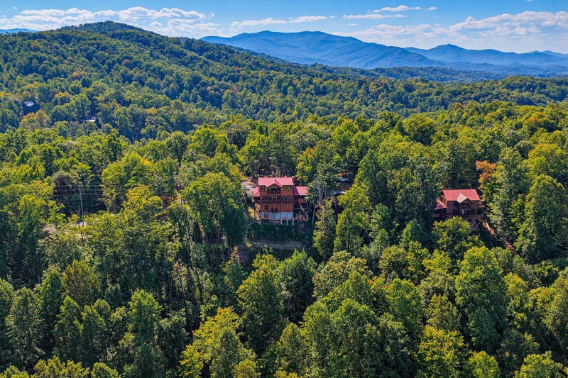 Aerial view of the property nestled in the Great Smoky Mountains, surrounded by lush forest canopy with sweeping mountain vistas stretching across the horizon.