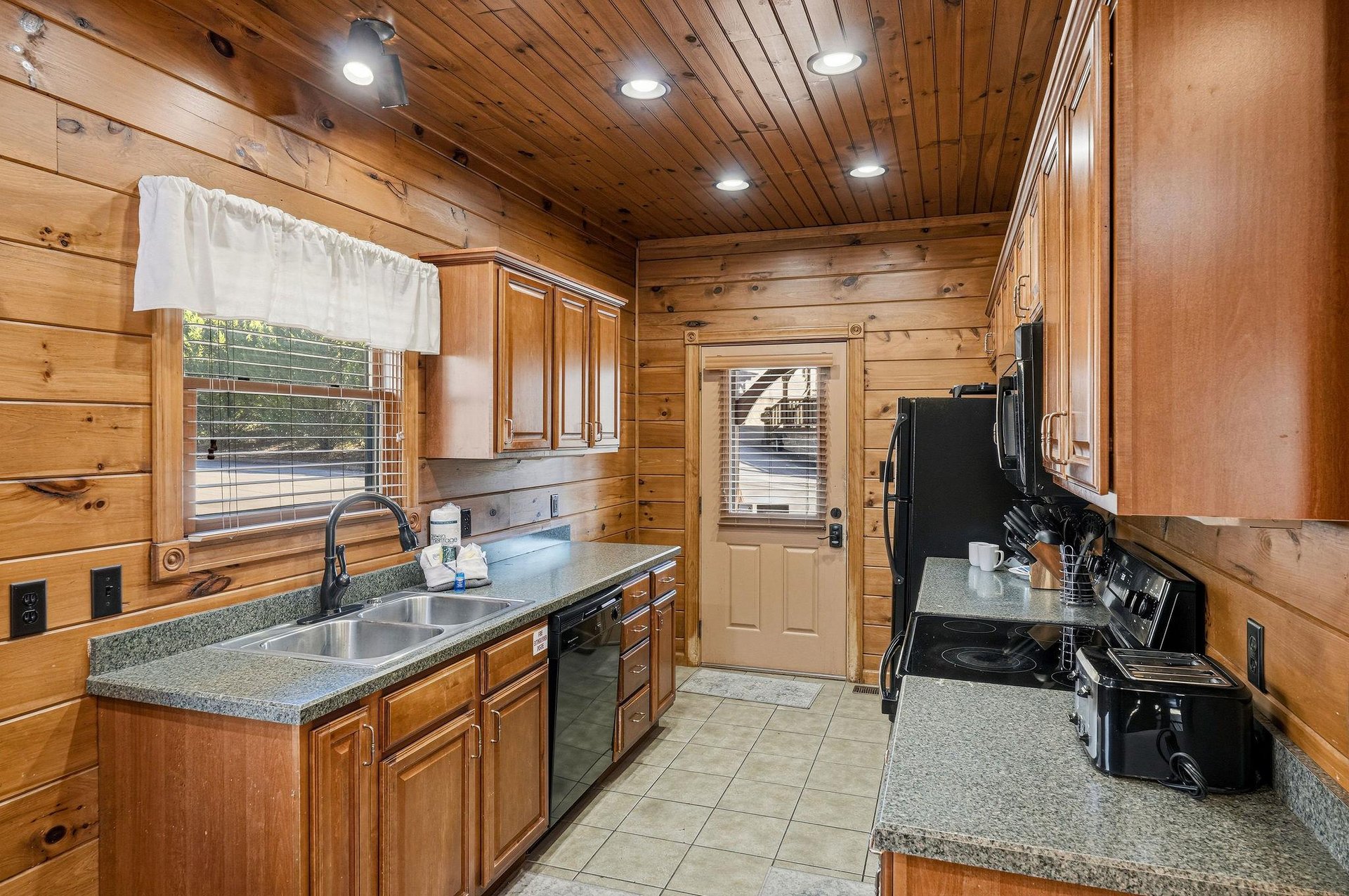 Youll love preparing meals in this fullyequipped kitchen, featuring warm wood accents, granite counters, stainless appliances, and natural light streaming through the windows.