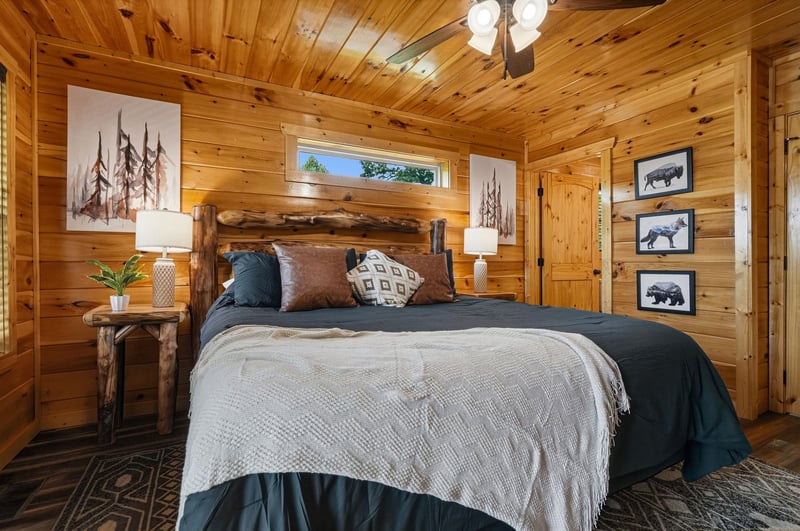 Drift off under warm wood beams and rustic wildlife art, where soft linens and layered textures wrap you in cozy cabin charm after a day of adventure.