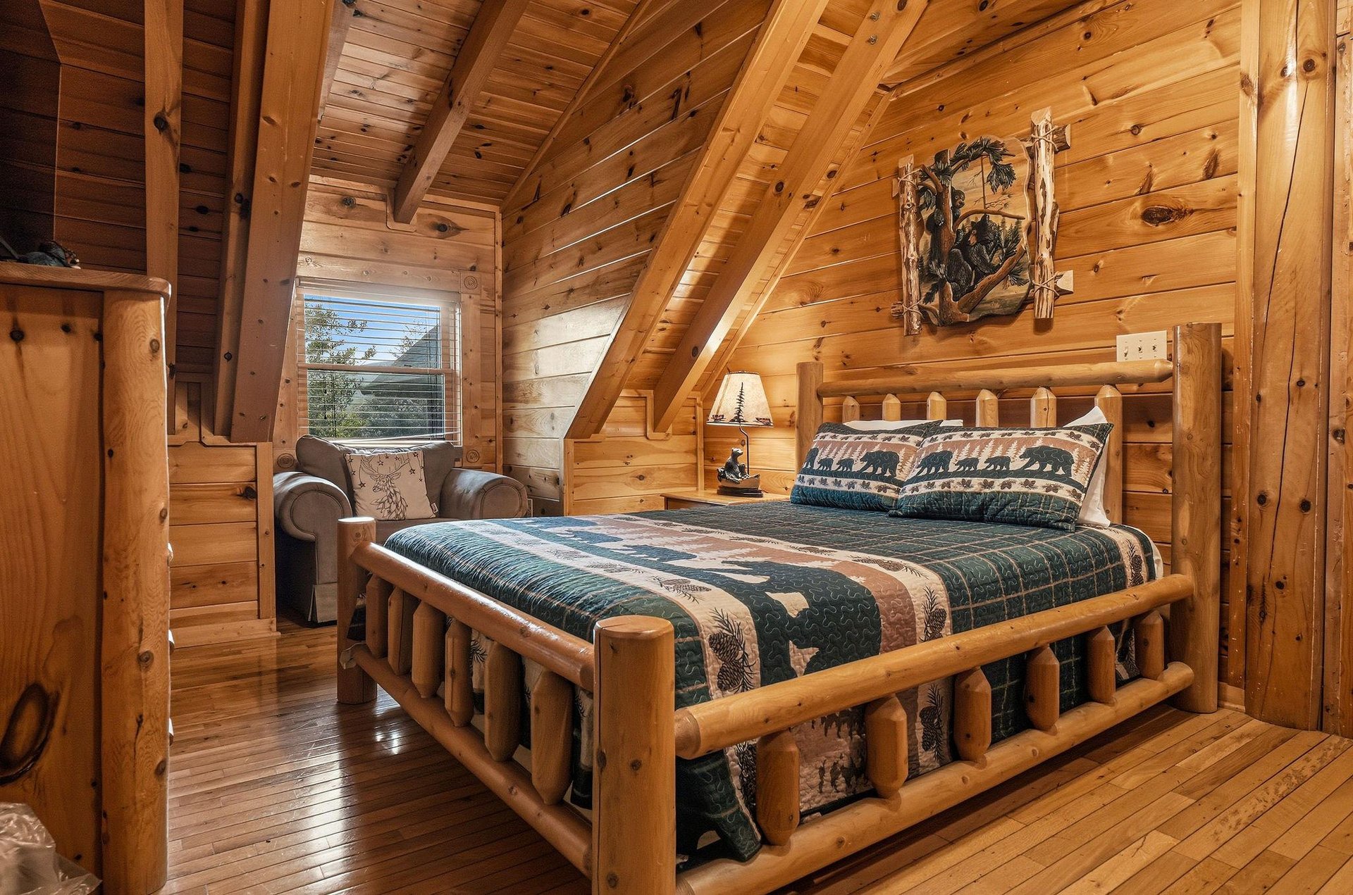 Unwind in this cozy cabin loft bedroom, where rustic log furnishings and warm wood tones create a serene mountain retreat for your restful escape.