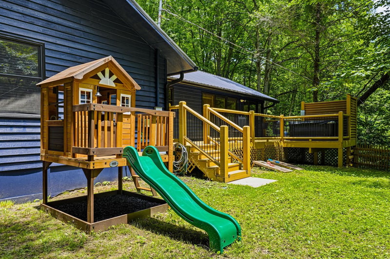 Your kids will love their own outdoor playhouse with a slide, while you enjoy a deck nestled in the trees. Perfect for family memories in nature.