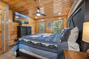 entry level bedroom w king bed, TV, dresser  balcony access