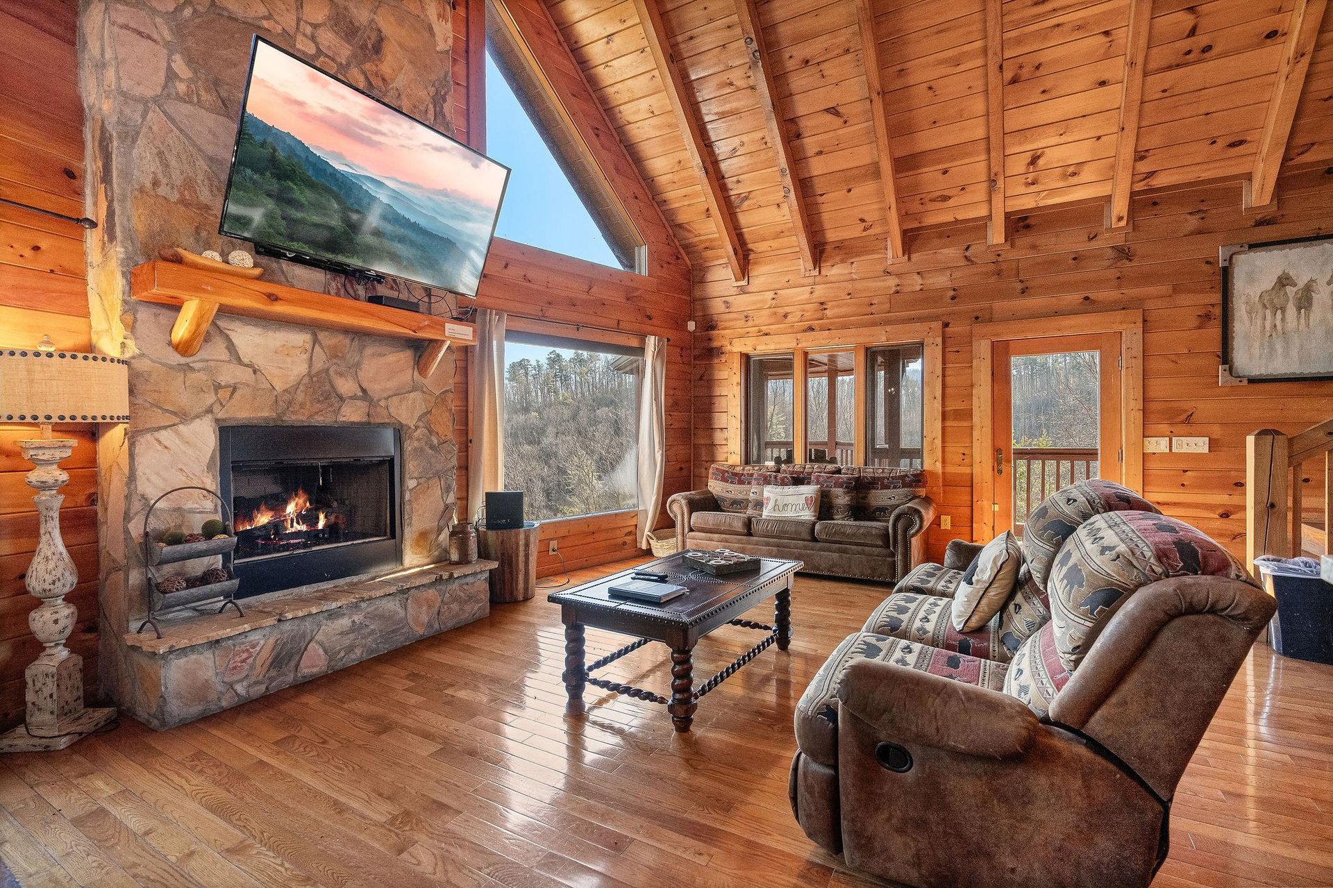 Living room with stone fireplace and big window view