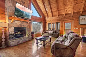 Living room with stone fireplace and big window view