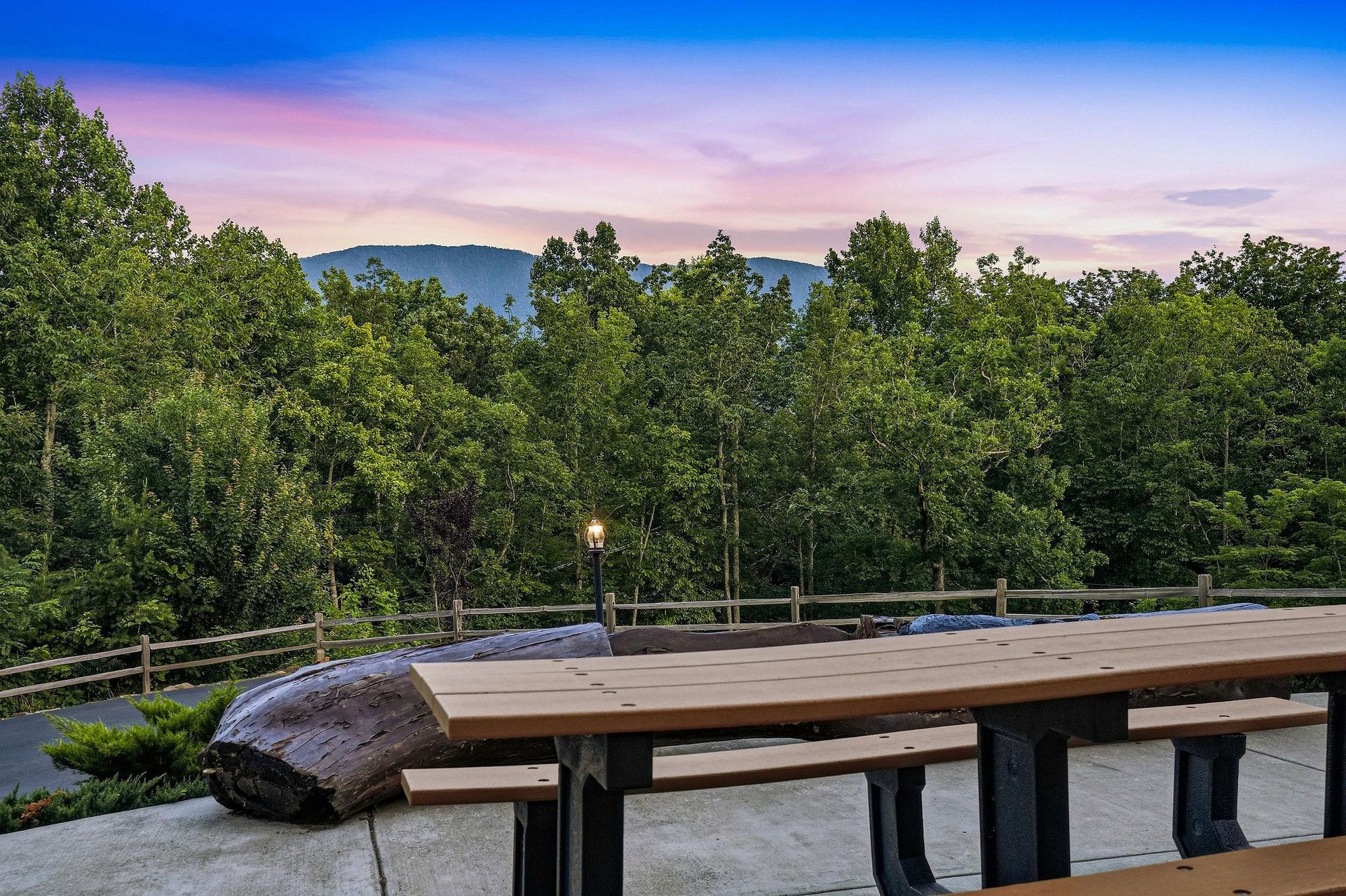 A scenic mountain vista borders the property, framed by lush forest and illuminated by soft twilight hues—perfect for peaceful evenings and breathtaking sunrises.