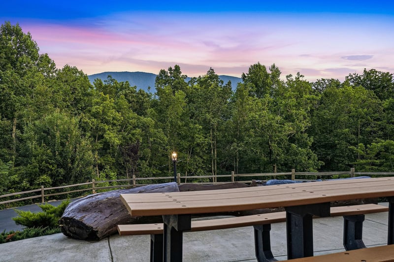 A scenic mountain vista borders the property, framed by lush forest and illuminated by soft twilight hues—perfect for peaceful evenings and breathtaking sunrises.