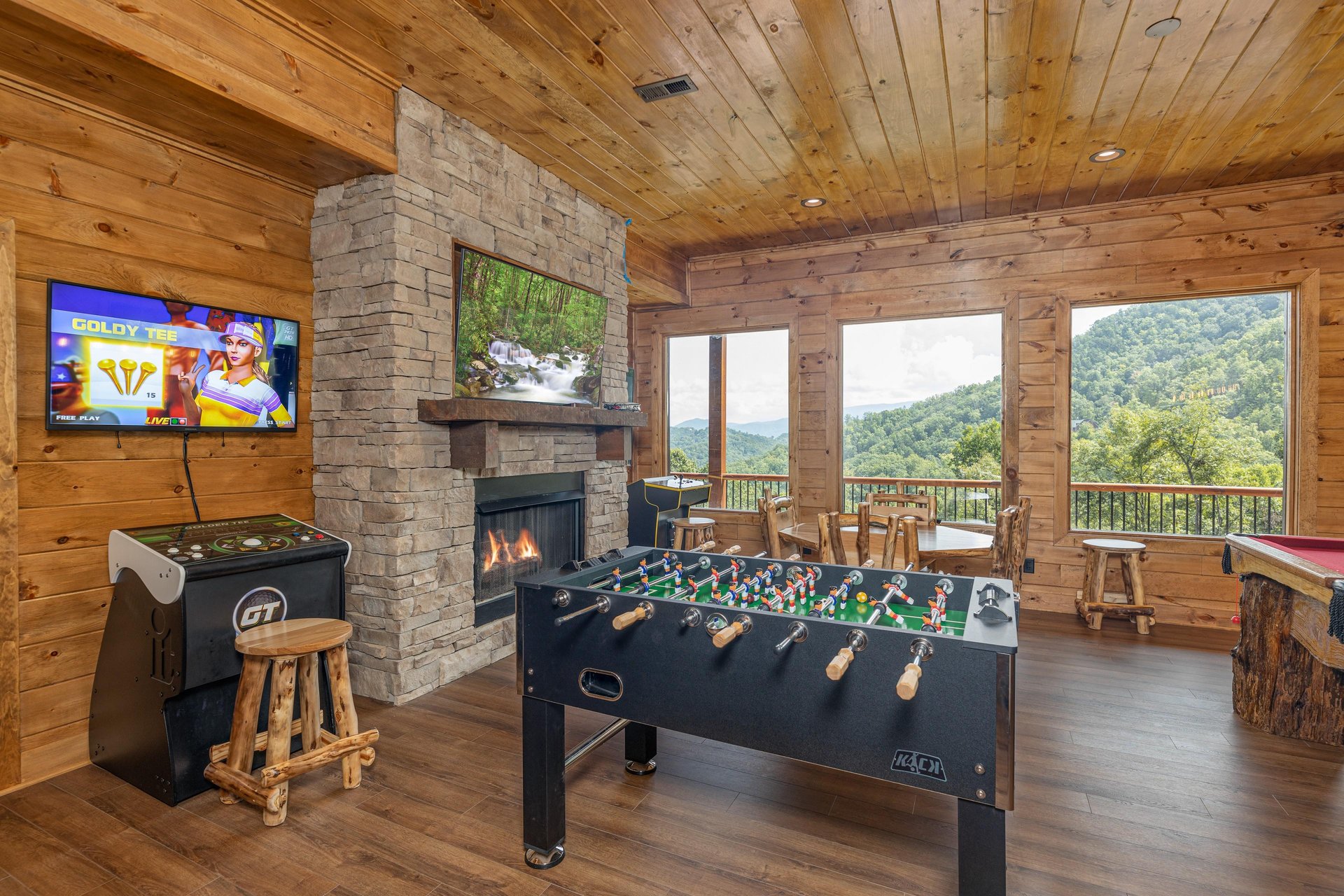 Game room with foosball, Golden Tee, fireplace, and TV