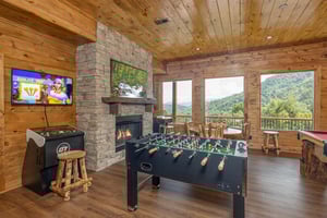 Game room with foosball, Golden Tee, fireplace, and TV