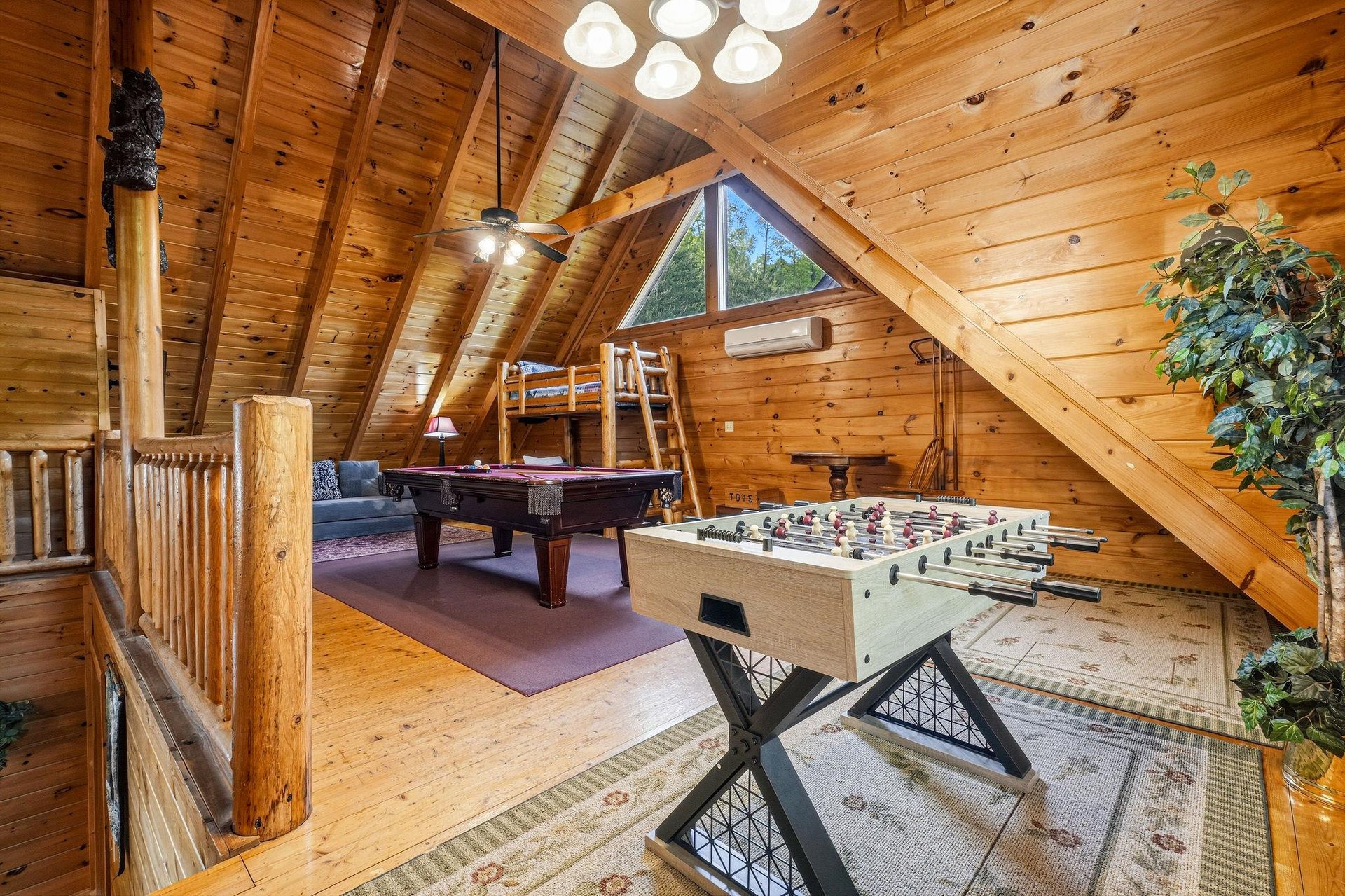 Your rustic game loft awaits with pool table, foosball, and cozy bunk nook under soaring wood beams—perfect for family fun.
