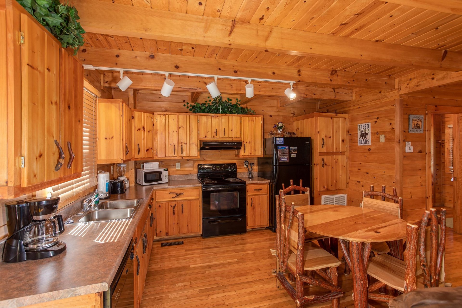 Dining table for four in the kitchen with black appliances at Dreams Do Come True, a 1bedroom cabin rental located in Pigeon Forge