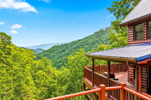 Rustic log cabin retreat nestled in the mountains with sweeping views of verdant valleys and forested peaks. Expansive wooden decks offer the perfect vantage point to embrace the breathtaking landscap