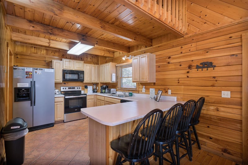 full kitchen with counter and chairs