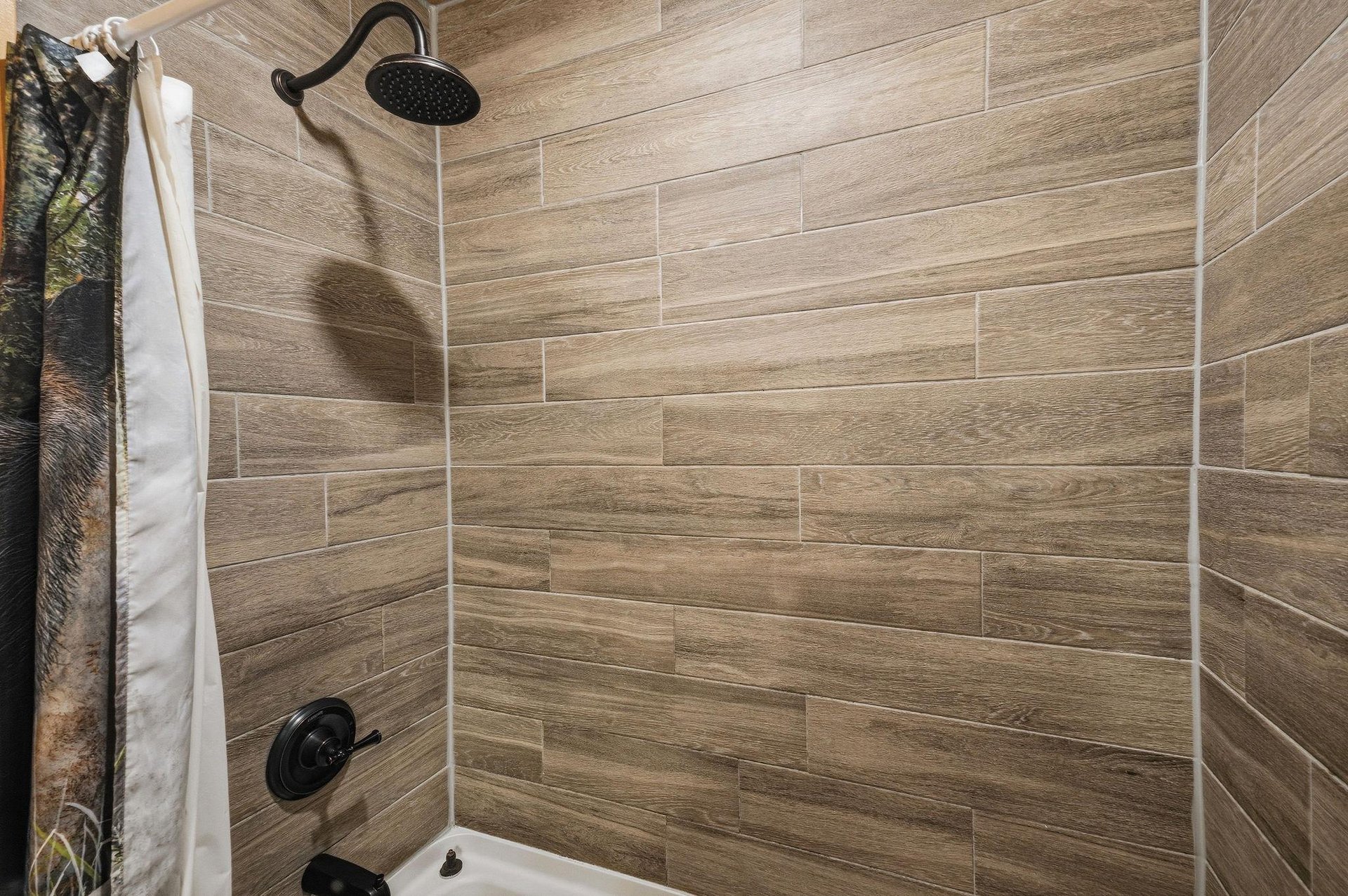 Step into your private shower with stylish woodlook tile and a rainfall showerhead—perfect for refreshing after a day of adventure.
