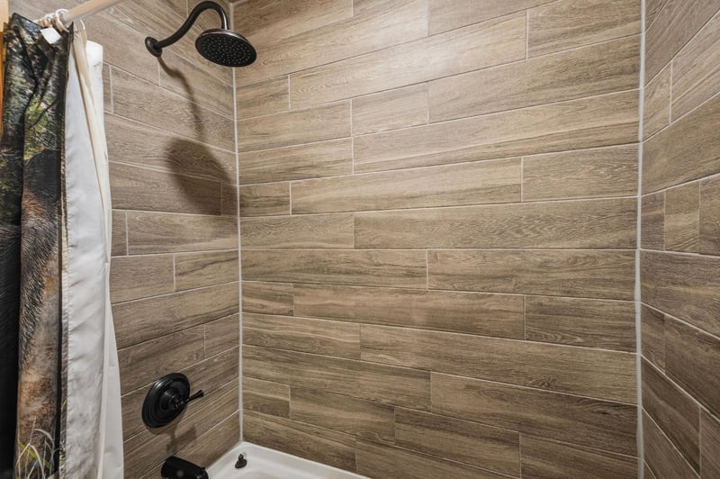 Step into your private shower with stylish woodlook tile and a rainfall showerhead—perfect for refreshing after a day of adventure.