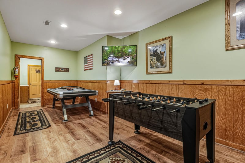 Step into your private game room featuring foosball and air hockey tables, perfect for friendly competition and cozy evening entertainment.