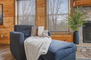 Curl up in your cozy armchair by the fireplace, wrapped in soft textures while natural light filters through the blinds.